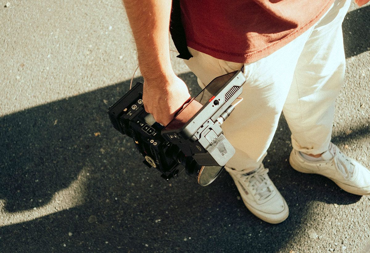 Colleague carrying a film camera on an outdoor shoot