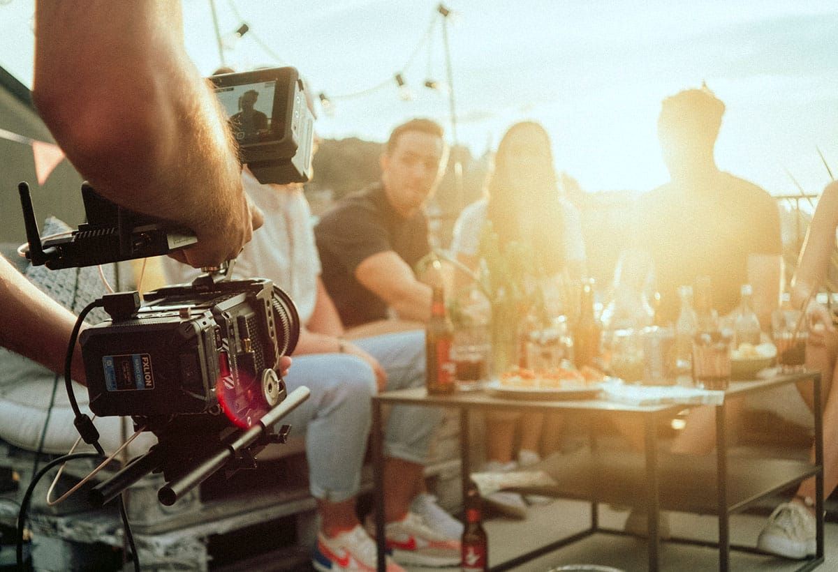 Film camera in front of the team at an evening gathering
